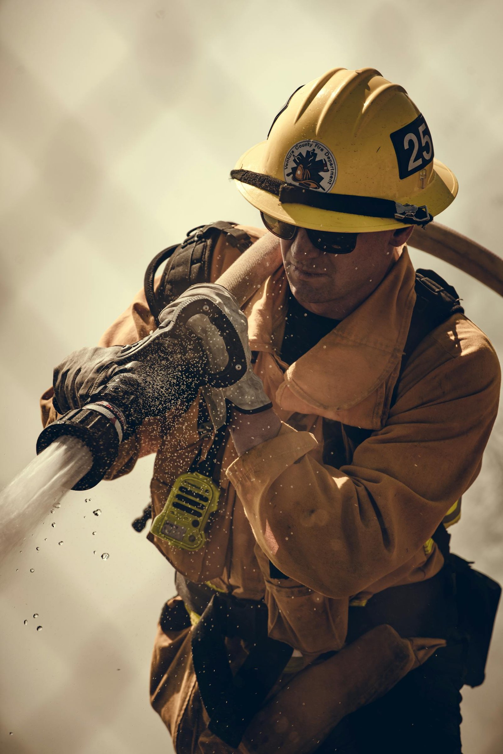 Firefighter equipped with protective gear sprays water demonstrating the vessent system active in all aspects of life and guides decision making in high stakes scenarios.